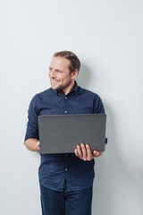 Smiling young businessman using a handheld laptop