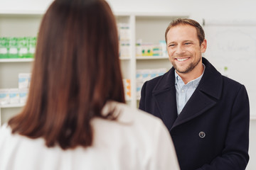 Fototapeta na wymiar Smiling man talking to a female pharmacist