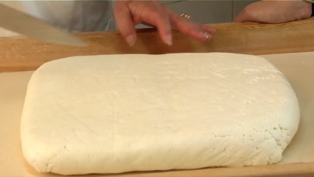 Close-up of making Halloumi cheese as it is sliced
