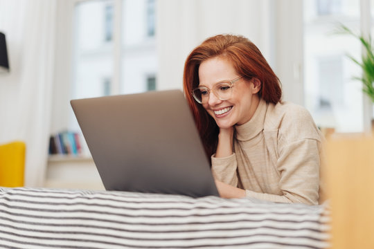 Young woman working on her laptop with a smile