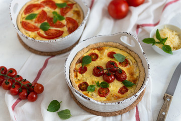 Homemade quiche with tomatoes, chicken, basil leaves and cheese. Close up