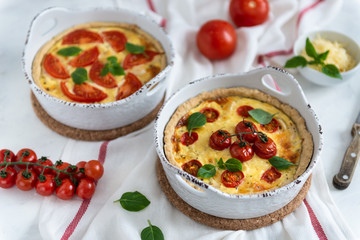 Homemade quiche with tomatoes, chicken, basil leaves and cheese. Close up