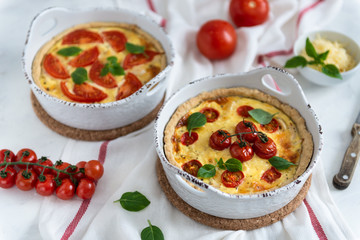 Obraz na płótnie Canvas Homemade quiche with tomatoes, chicken, basil leaves and cheese. Close up