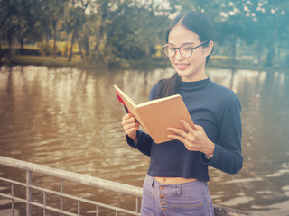 beautiful young Asia woman with reading book at outdoor garden.