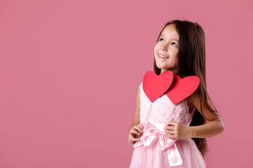 cute little girl in a pink dress holding a paper heart