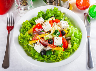 Greek salad with vegetables on white plate. Close up