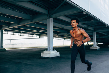 Bare chested sportsman running at bridge outdoors