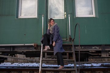 young woman in train station at sunny winter day