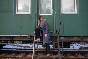 young woman in train station at sunny winter day