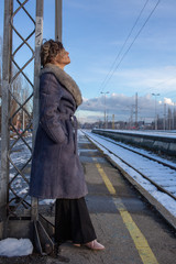 young woman in train station at sunny winter day