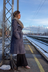 young woman in train station at sunny winter day