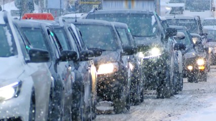 Snow storm in winter city, falling snow illuminated by cars headlights. Slow motion, 4K UHD.