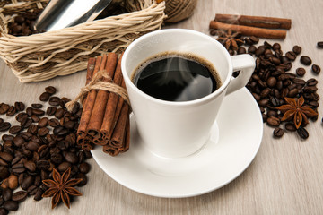 coffee still life from a cup of coffee, beans and cinnamon sticks