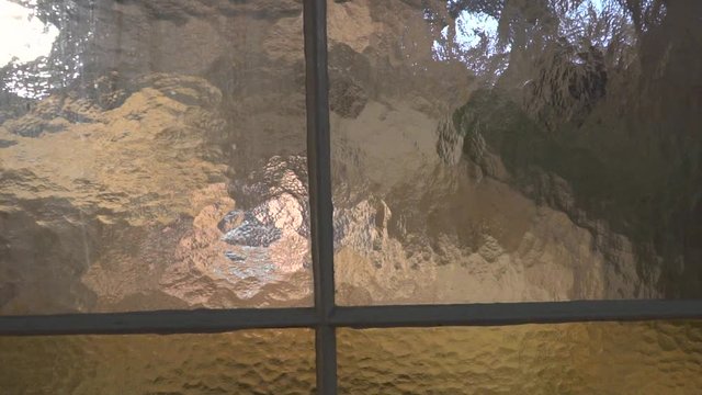Push in towards tainted windows with lights behind them