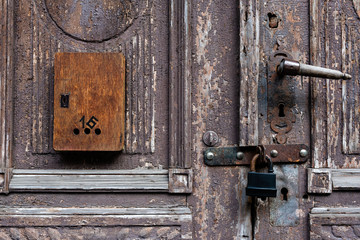 Old wooden door with damaged color and mailbox.