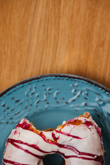 Top-shot of a bitten doughnut on a plate