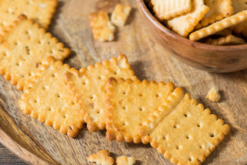 Crackers with cherry jam on a wooden plate on a wooden background. Rustic style