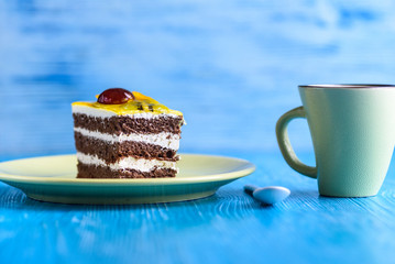 Biscuit cake with fruit tops photographed close-up on wooden background.