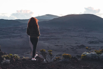 Girl watching the sunrise at La Plaine des Sables, in Reunion Island
