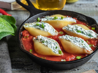 cooked pasta conchiglioni stuffed spinach and cheese, tomato sauce