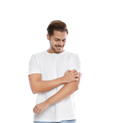 Young man scratching arm on white background. Annoying itch