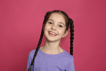 Portrait of little girl laughing on color background