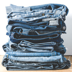 A stack of old jeans on a light background