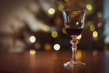 Elegant glass of red wine on the background of a Christmas tree