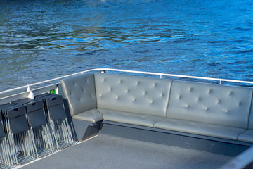 Soft sofas on board a pleasure yacht against the backdrop of water