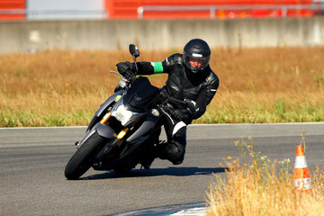 A man leaning over a motorcycle in a curve on a circuit