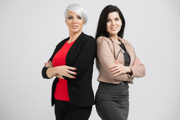 Portrait of waist-deep Two young girls standing back-to-back isolated on white background