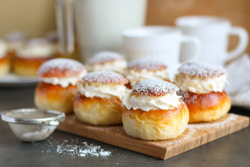 Obraz na płótnie Canvas Homemade semla or vastlakukkel (in Estonia) is a traditional sweet roll with whipped cream made in Scandinavic and Baltic countries for Shrove Tuesday or related days