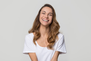 Happy cheerful young woman with beautiful face, teeth and hair laughing looking at camera on white...
