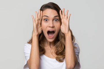 Amazed surprised young woman with astonished face feeling excited screaming looking at camera, funny shocked girl with open mouth stunned on isolated on white light background studio wall, portrait