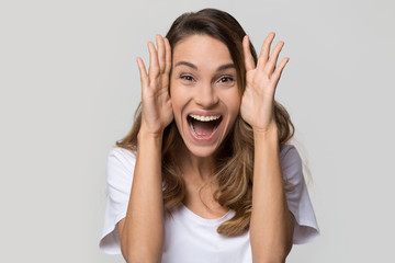 Excited young woman feeling amazed by unbelievable sale looking at camera screaming with joy...