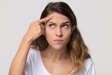 Dissatisfied stressed depressed young woman touch forehead worried about skin wrinkle isolated on studio background, cosmetology botox injection anti aging cream concept, cosmetology facial treatment - obrazy, fototapety, plakaty