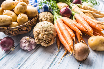 Assortment of fresh vegetables on wooden table. Carrot parsnip garlic celery onion and kohlrabi