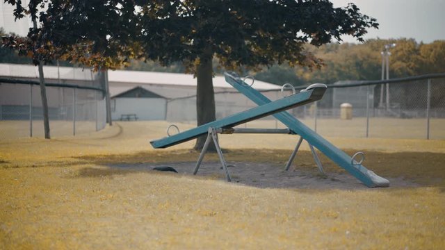 Abandoned Empty Moving Seesaw Teeter Totter In Children's Playground During Autumn 4K ProRes