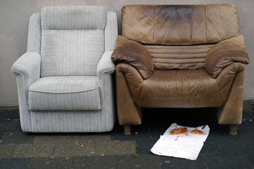 Essensplatz Obdachloser / Zwei Couchsessel stehen auf einem Gehweg mit Essensresten von Obdachlosen...
