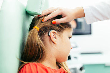 Fototapeta premium Young girl at medical examination or hearing aid checkup in otolaryngologist's office
