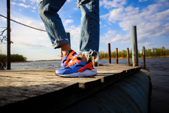 legs with jeans on river pier , sport legs , sport shoes  - Powered by Adobe