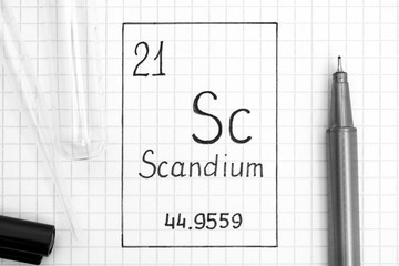 Handwriting chemical element Scandium Sc with black pen, test tube and pipette.