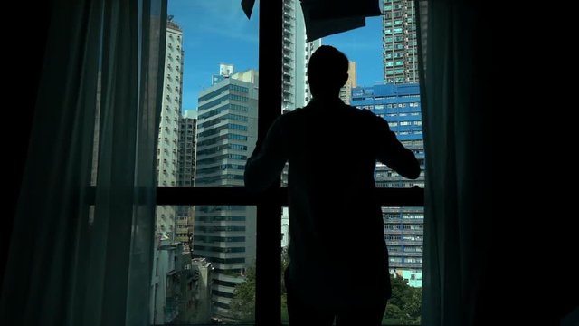 Upset businessman throwing documents by window in office, super slow motion