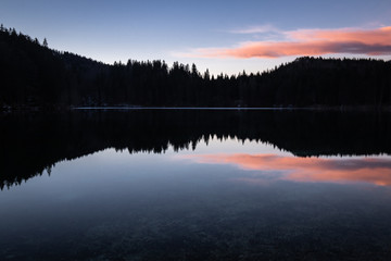 scenic mirror reflection on fusine lakes in sunset, italy