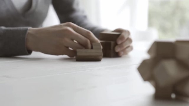 Woman playing with a wooden brain teaser puzzle