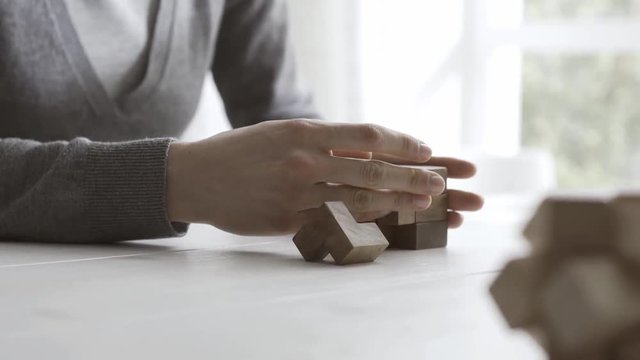 Woman playing with a wooden brain teaser puzzle