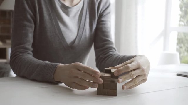 Woman solving a wooden brain teaser puzzle