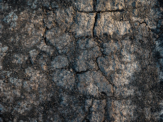 Dark dry cracked ground or soil background texture surface, top view. Global warming on earth and dryness concept