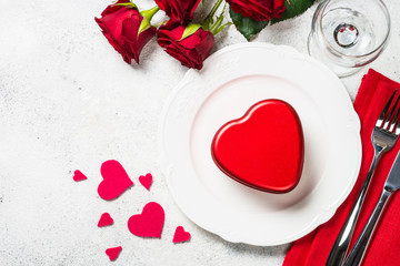 Valentines day table setting with plate, roses and present. 