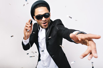 Portrait expressing brightful positive emotions of handsome guy in hat, suit, black sunglasses...